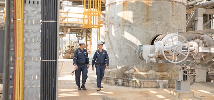 Field Service workers walking within an refinery plant