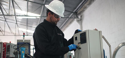Field engineer operating industrial equipment inside a manufacturing facility