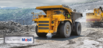 Large haul truck operating in an open-pit mine with Mobil signage.